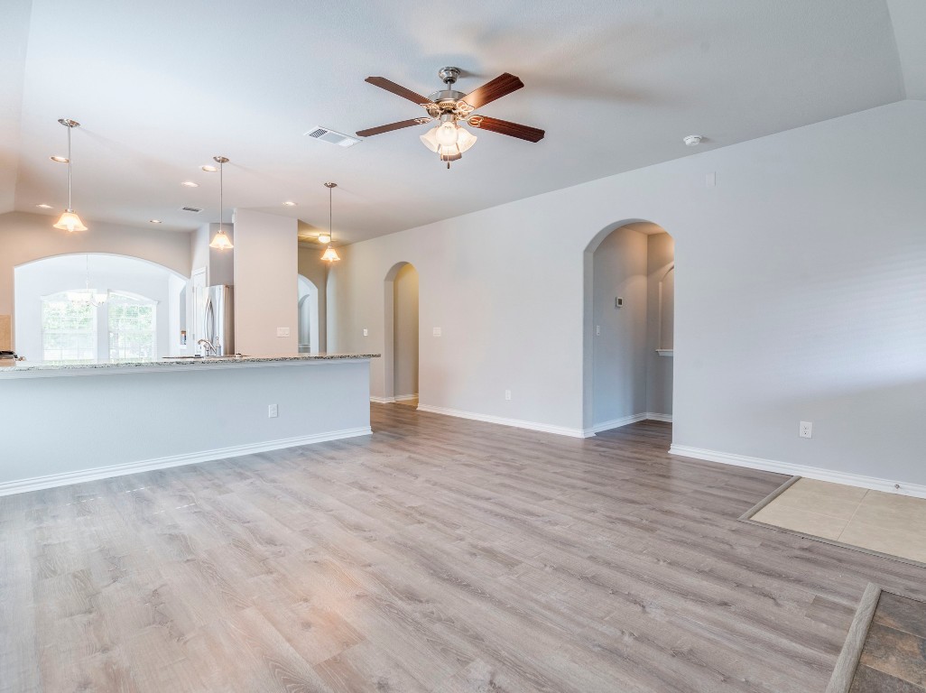 225 Razzmatazz Trail Buda, TX 78610 - Photo 12 of 28 an empty room with wooden floor and ceiling fan