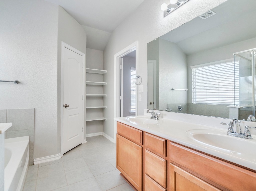 225 Razzmatazz Trail Buda, TX 78610 - Photo 18 of 28 a bathroom with a sink double vanity and a tub