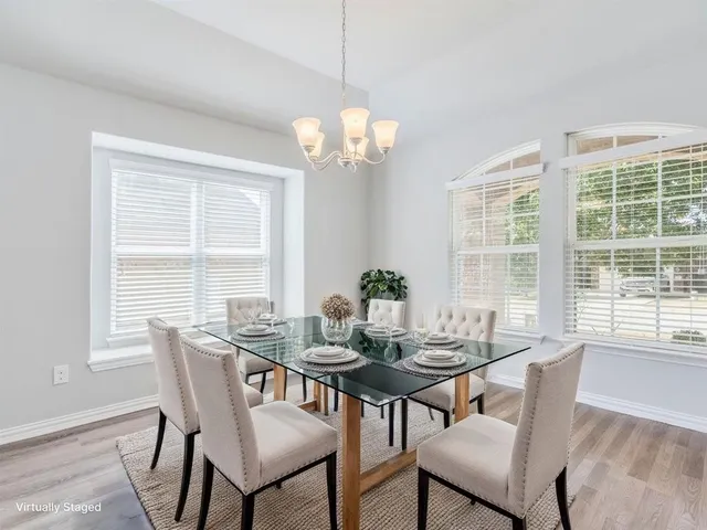 a view of a dining room with furniture a chandelier and wooden floor