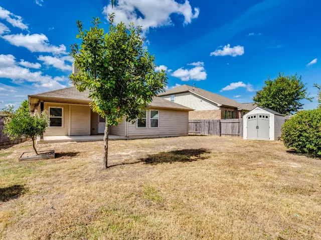 a view of a house with a yard and tree