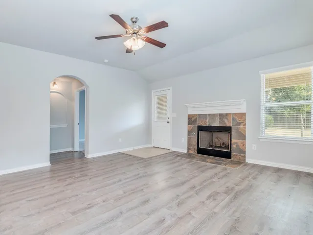an empty room with windows fireplace and a sink