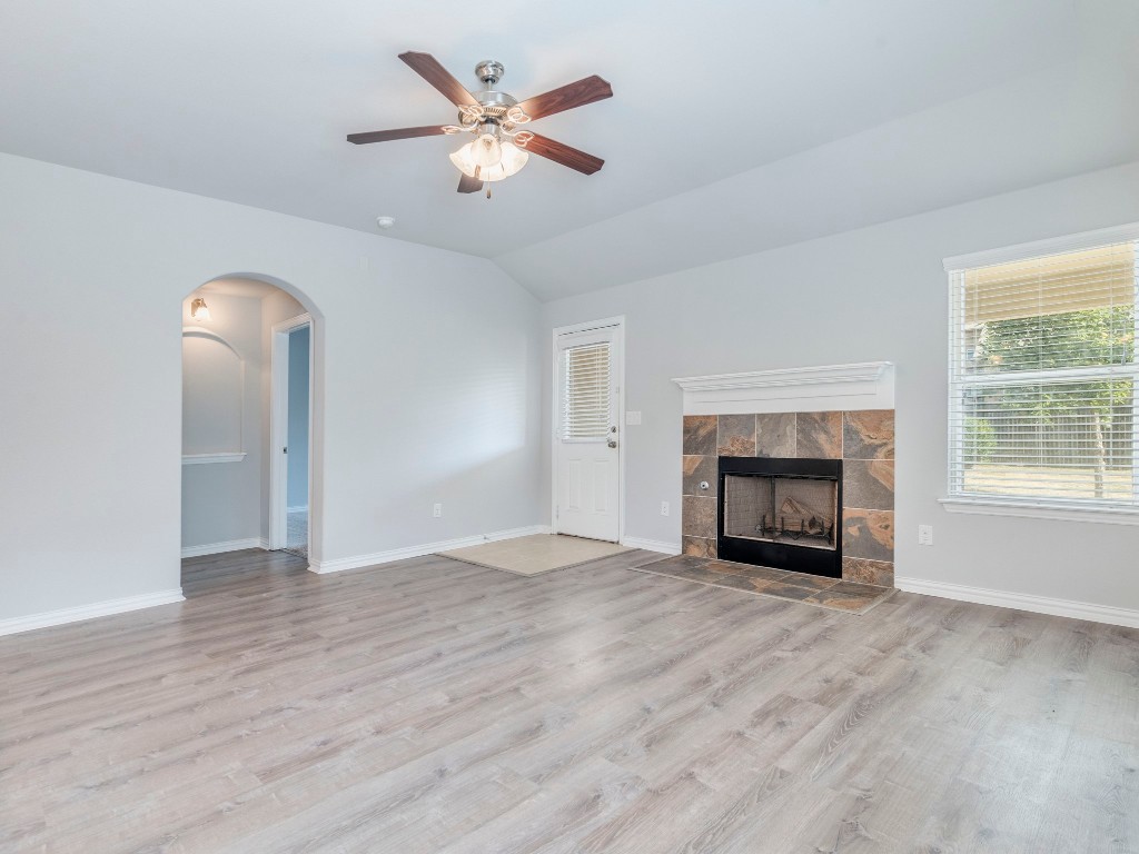225 Razzmatazz Trail Buda, TX 78610 - Photo 10 of 28 an empty room with windows fireplace and a sink