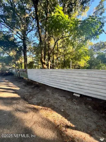 a view of a yard with wooden fence