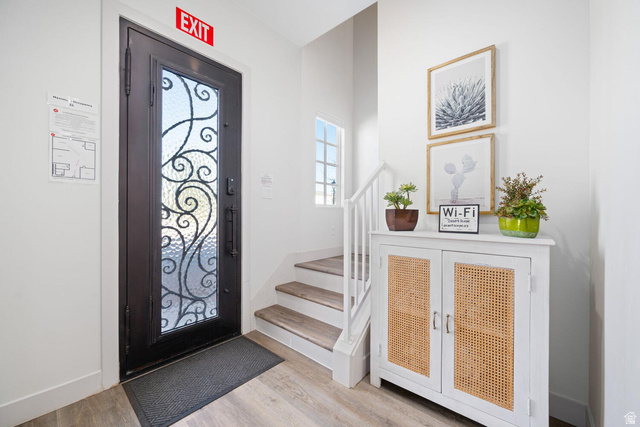 4281 Canterbury Road Hurricane, UT 84737 - Photo 10 of 24 Entryway featuring a dark-finish door with decorative glass, wood-finish flooring, white baseboards, and a staircase with white risers and wood treads