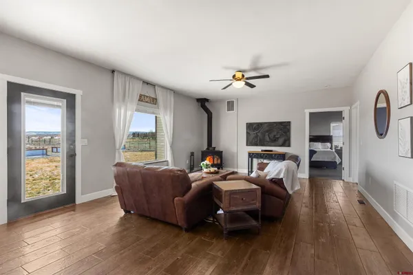 a living room with furniture two window and a wooden floor