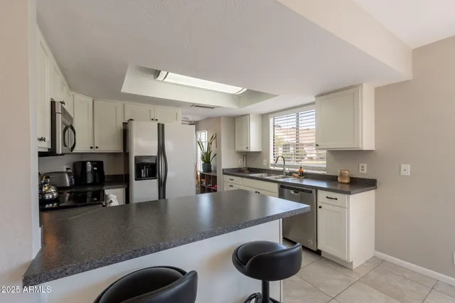 a kitchen with stainless steel appliances granite countertop a sink a stove counter space and cabinets