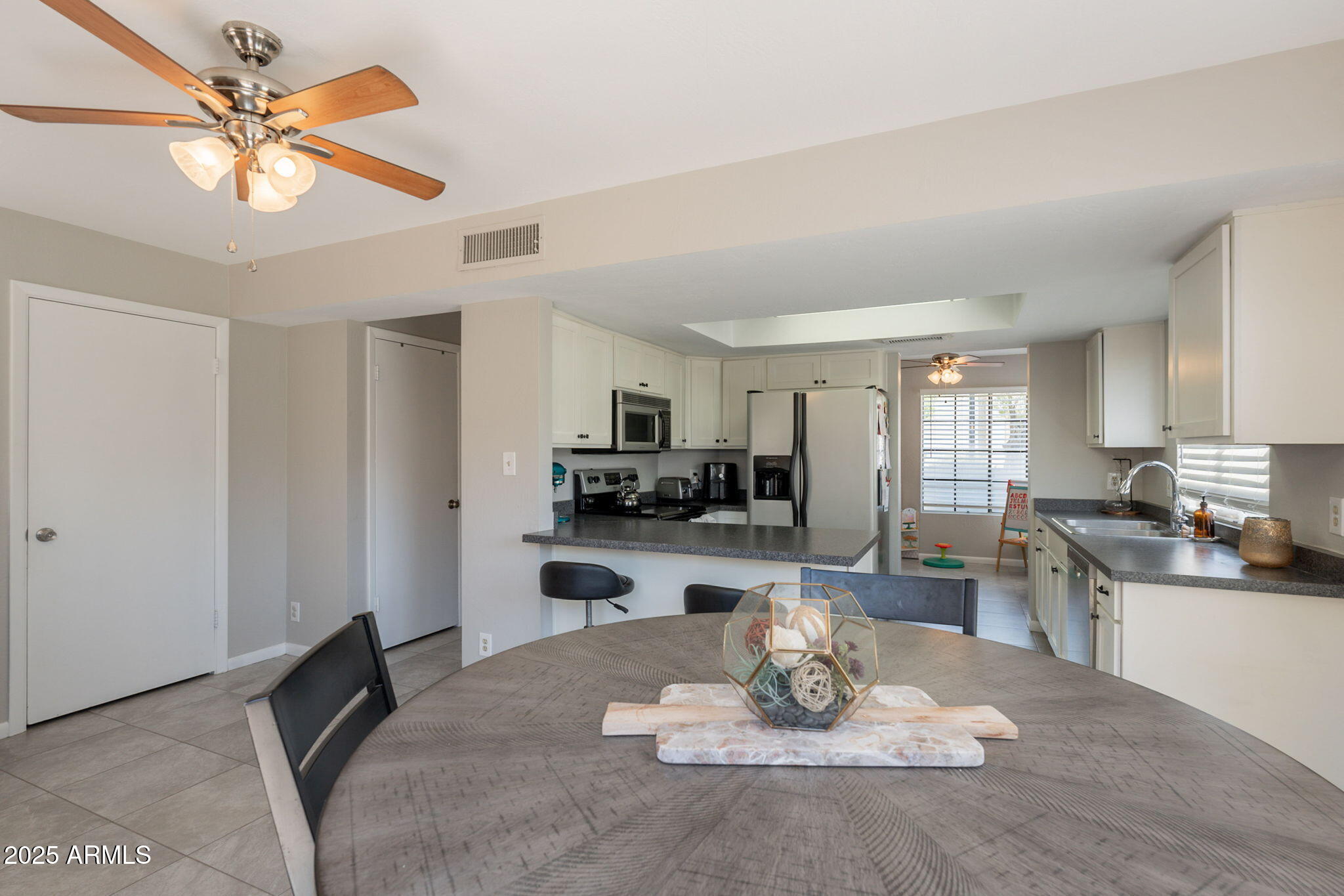 2455 East Broadway Road, Unit 115 Mesa, AZ 85204 - Photo 9 of 17 a kitchen with a table chairs stove and refrigerator