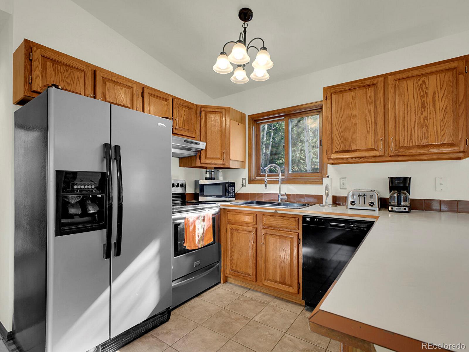 638 Impala Trail Bailey, CO 80421 - Photo 11 of 50 a kitchen with granite countertop a refrigerator stove top oven a sink and dishwasher