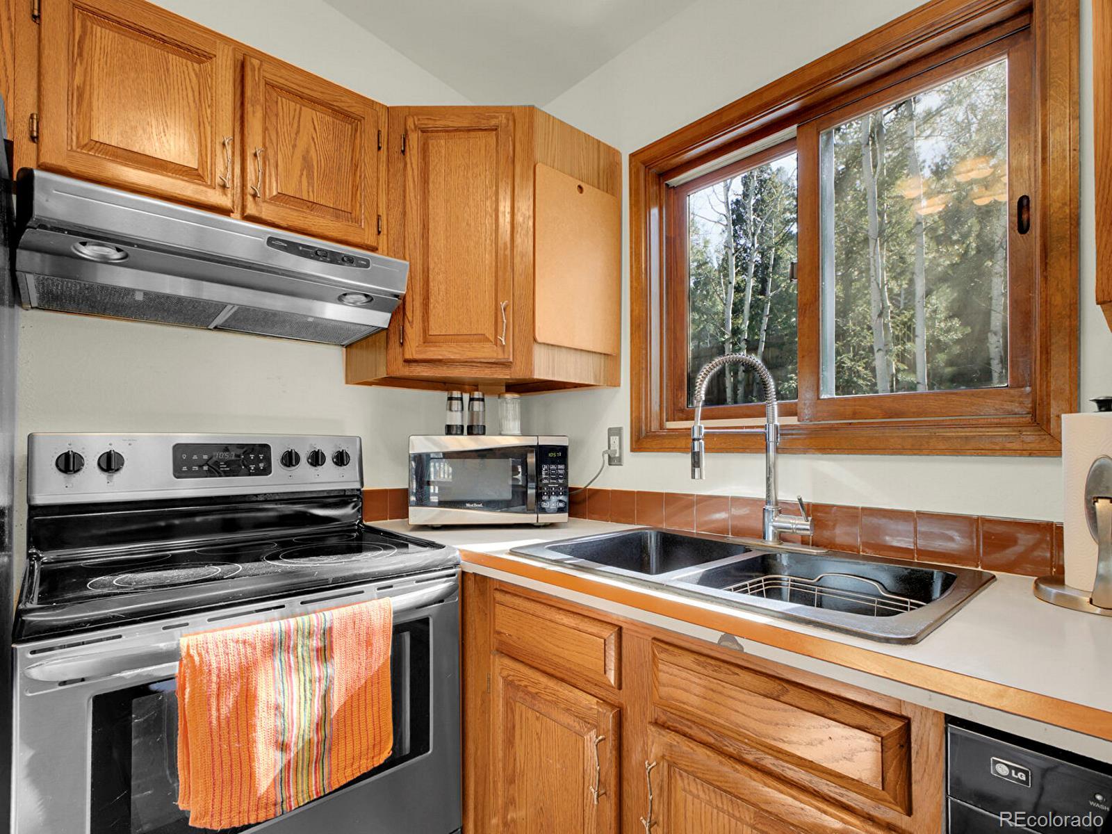 638 Impala Trail Bailey, CO 80421 - Photo 13 of 50 a kitchen with stainless steel appliances granite countertop a sink a stove and cabinets