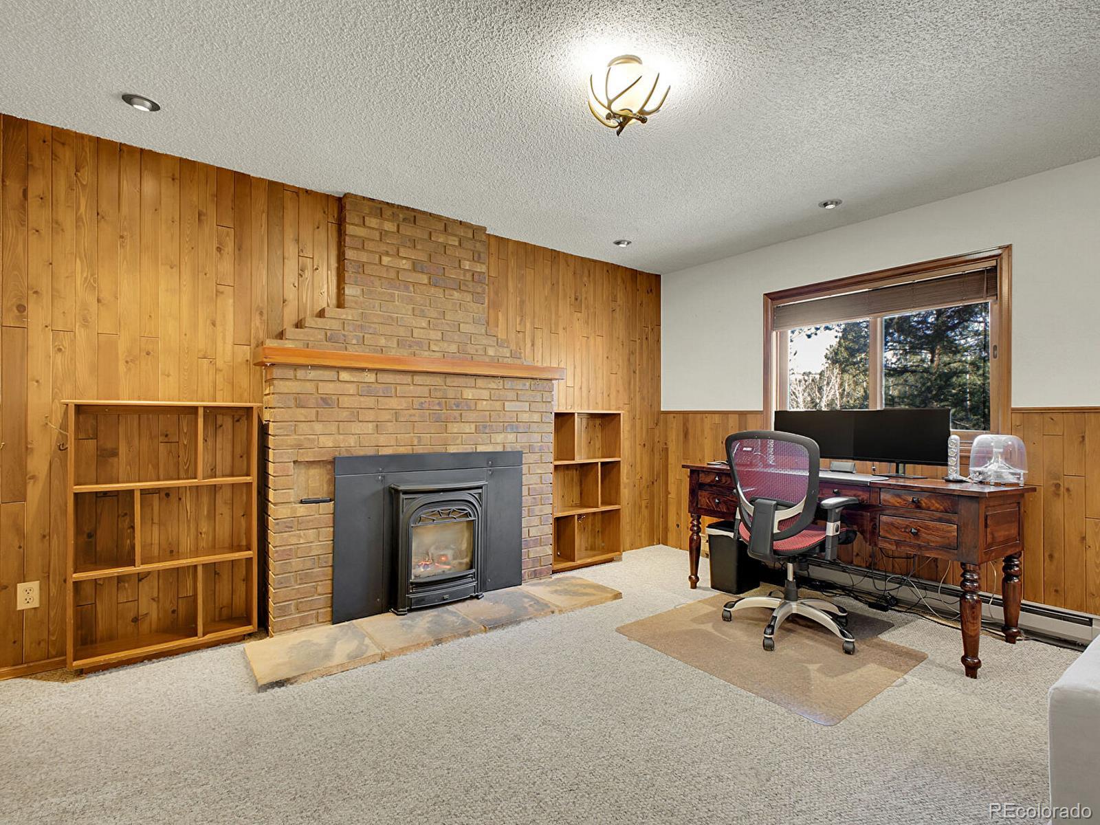 638 Impala Trail Bailey, CO 80421 - Photo 23 of 50 a view of a livingroom with a fireplace and workspace