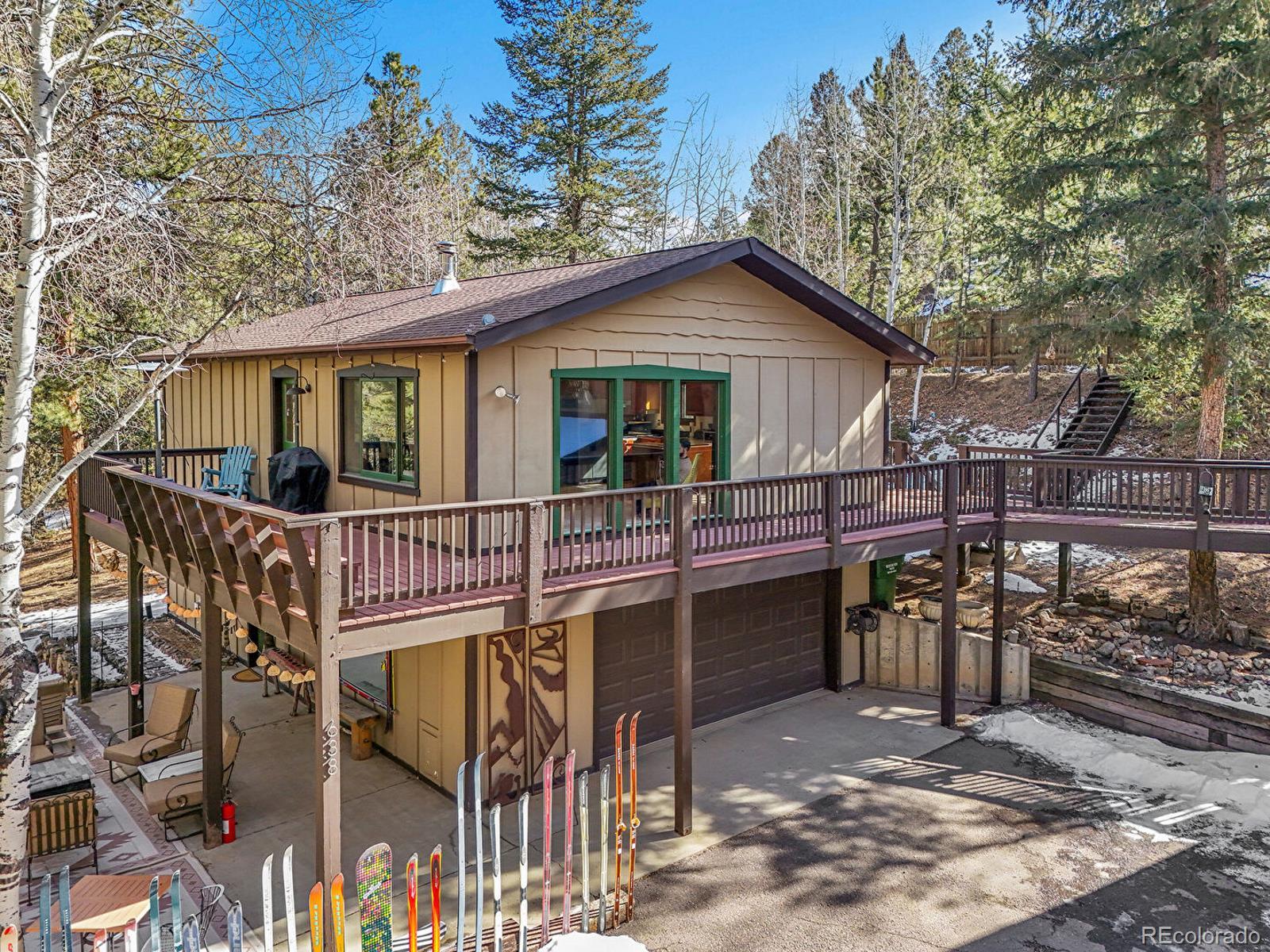 638 Impala Trail Bailey, CO 80421 - Photo 3 of 50 a view of a house with a yard and wooden deck