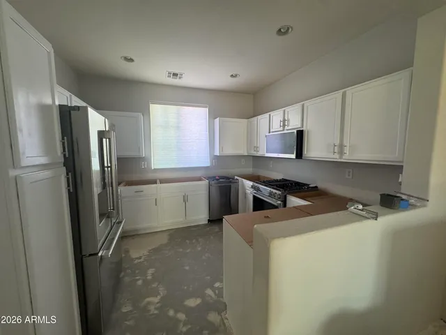 a kitchen with a refrigerator sink and cabinets
