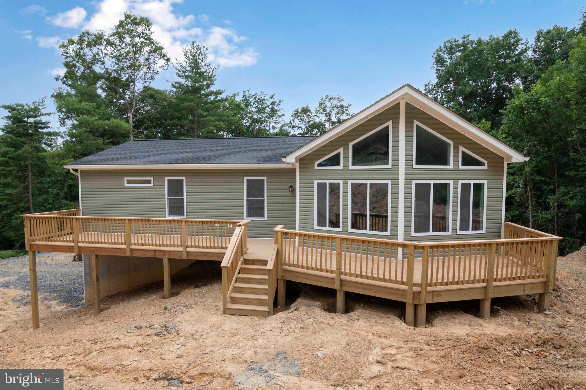 a view of a house with a wooden deck and a yard