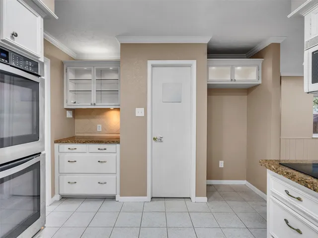 a view of an empty room and kitchen