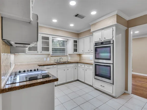 a view of a refrigerator in kitchen and an empty room