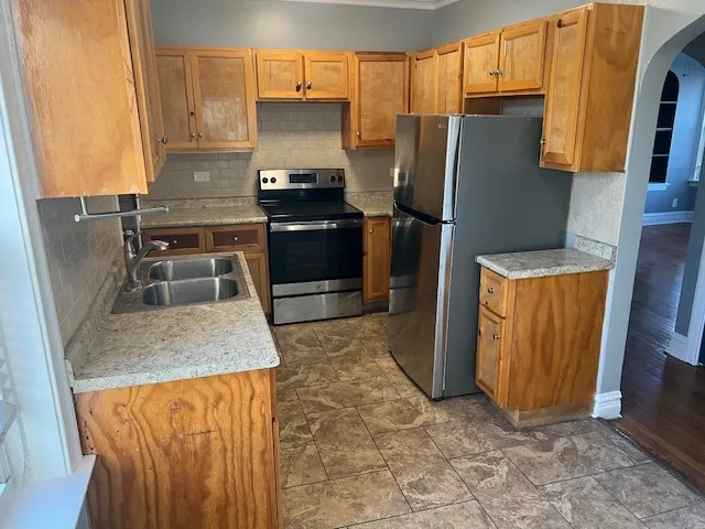 a kitchen with granite countertop a refrigerator and a sink
