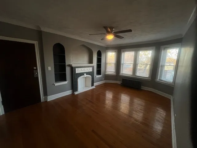 an empty room with windows and fireplace