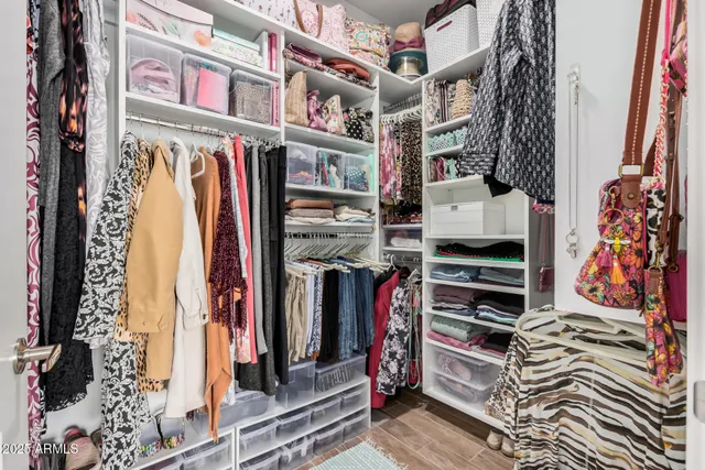 a view of walk in closet with clothes and shoes