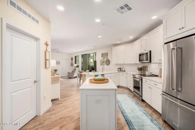 a kitchen with white cabinets and stainless steel appliances