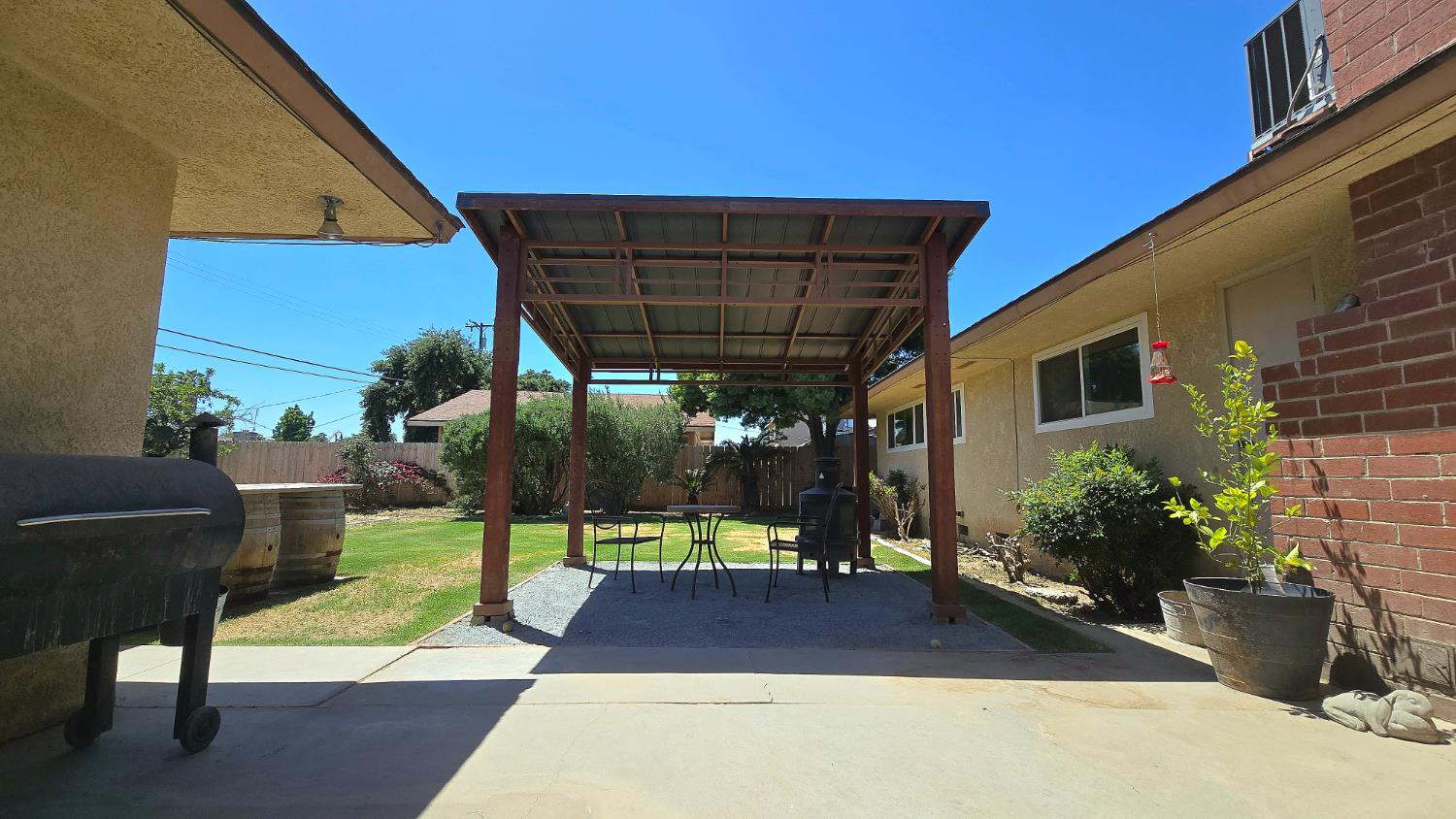 1205 Pine Street Selma, CA 93662 - Photo 36 of 41 a view of a patio with table and chairs potted plants and floor to ceiling window