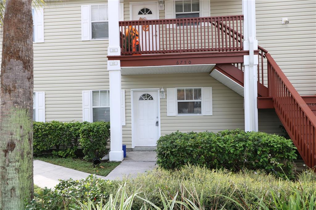 6750 Moonglow Drive, Unit 102 Port Richey, FL 34668 - Photo 1 of 26 a view of a house with a small yard and plants
