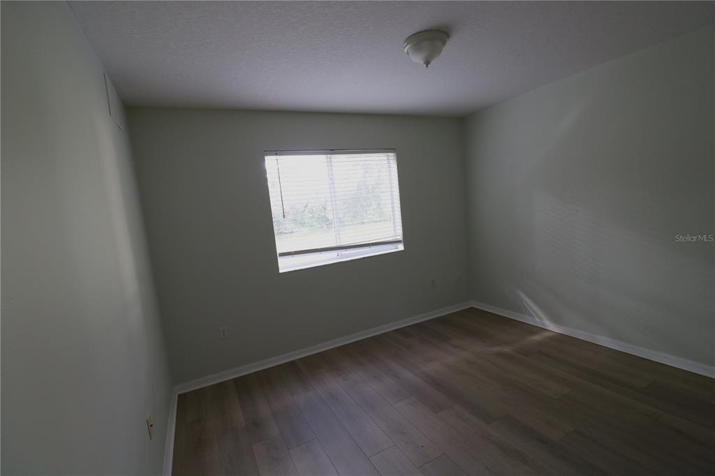6750 Moonglow Drive, Unit 102 Port Richey, FL 34668 - Photo 20 of 26 an empty room with wooden floor and windows