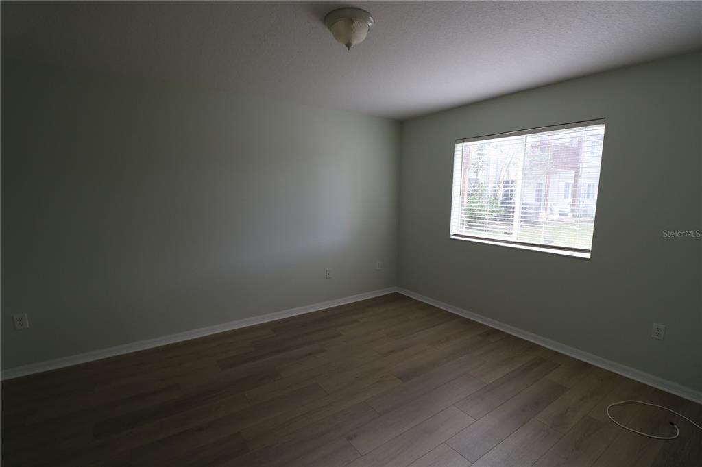 6750 Moonglow Drive, Unit 102 Port Richey, FL 34668 - Photo 10 of 26 an empty room with wooden floor and windows