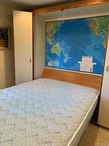 a bed sitting in a bedroom next to a window