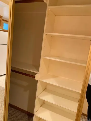 a view of walk in closet with empty racks