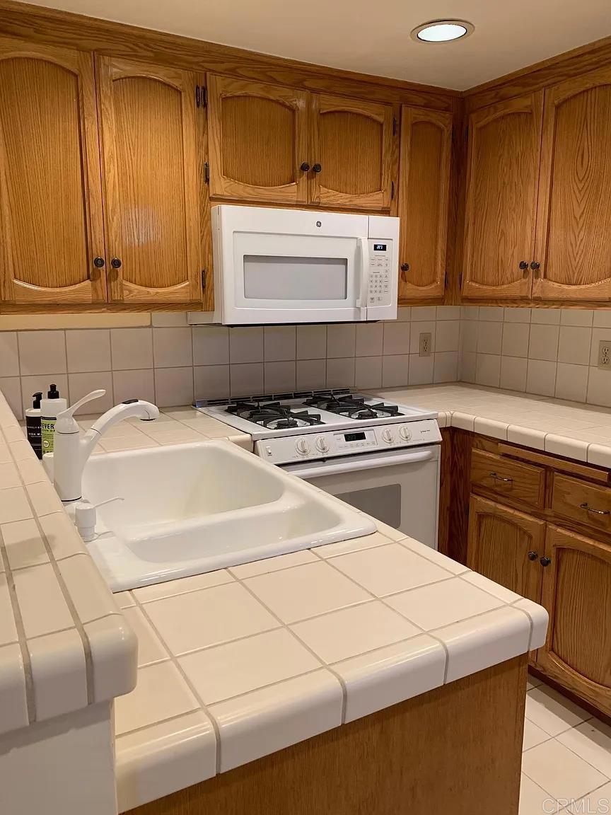 714 Passiflora Avenue, Unit S Encinitas, CA 92024 - Photo 7 of 16 a white kitchen with sink and cabinets