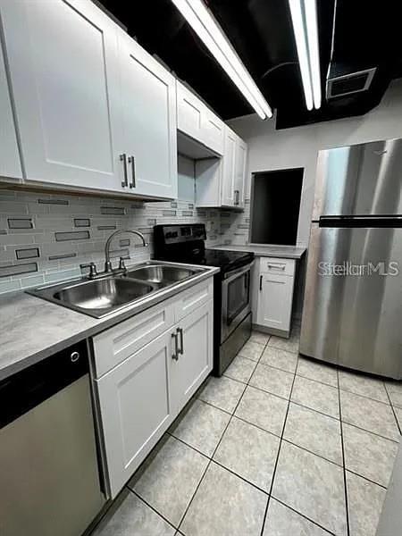 703 Southwest 75th Street, Unit 106 Gainesville, FL 32607 - Photo 3 of 8 a kitchen with stainless steel appliances granite countertop a sink a stove a microwave and a refrigerator