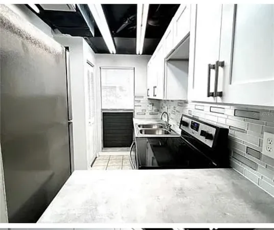 a kitchen with granite countertop a stove sink and cabinets