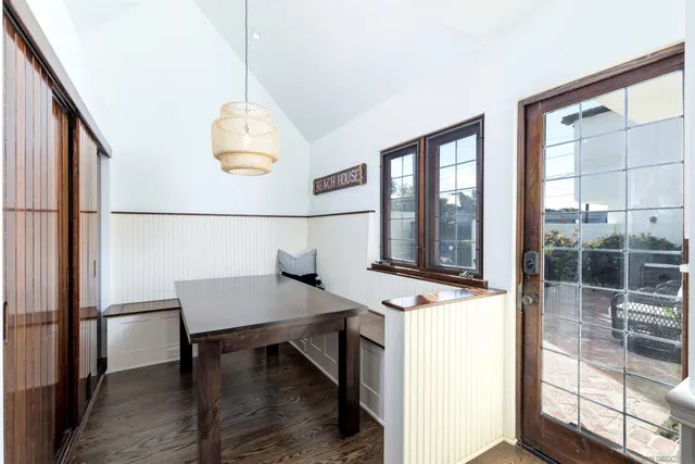 a workspace with kitchen island a dining table chairs and a large window