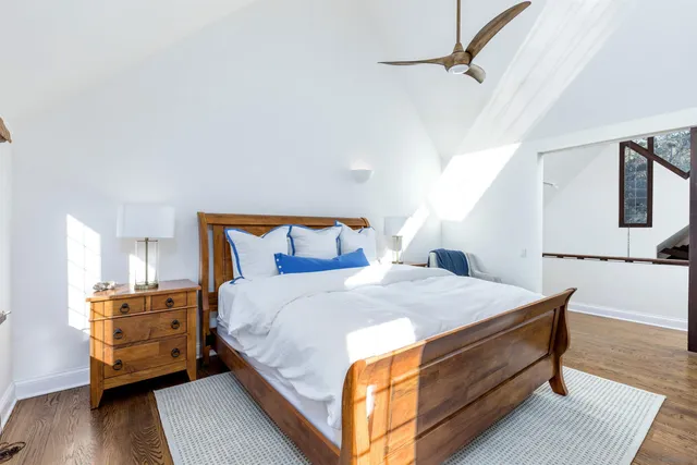 a bed sitting in a bedroom next to a window with a dresser