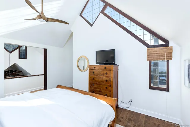a bedroom with a bed and a flat tv screen on wall