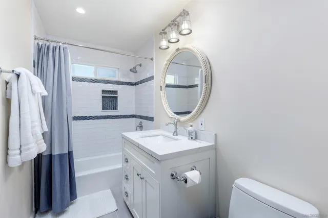 a bathroom with a sink a toilet and a mirror