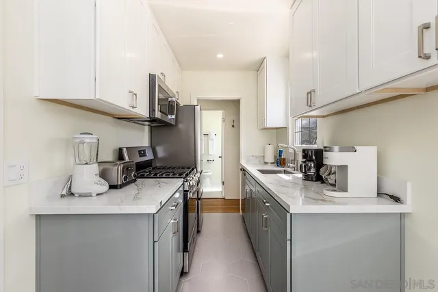 a kitchen with stainless steel appliances a sink stove top oven and cabinets