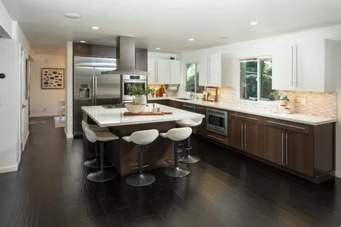 a kitchen with a dining table chairs appliances and cabinets