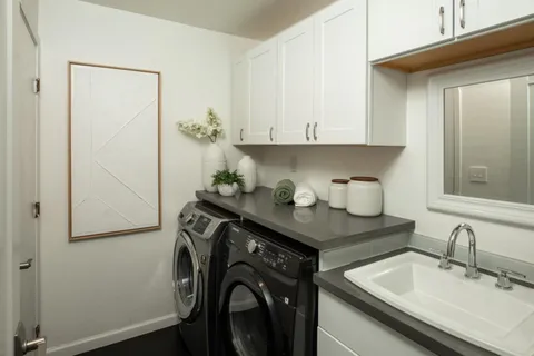 a utility room with cabinets washer and dryer