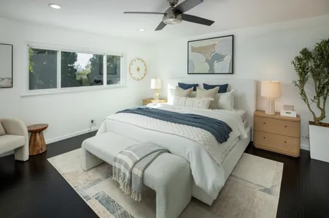 a bedroom with a bed and wooden floor