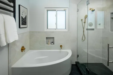a white bath tub sitting next to a shower