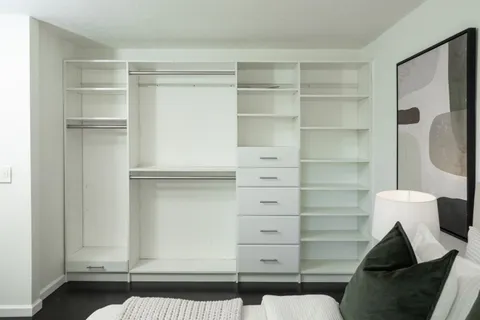 a view of walk in closet with empty racks