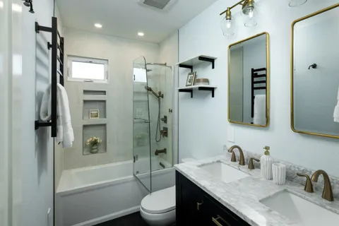 a bathroom with a granite countertop sink toilet and shower