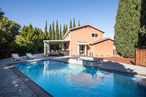 a view of a house with pool and sitting area
