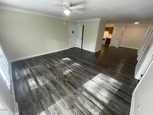 a view of empty room with wooden floor
