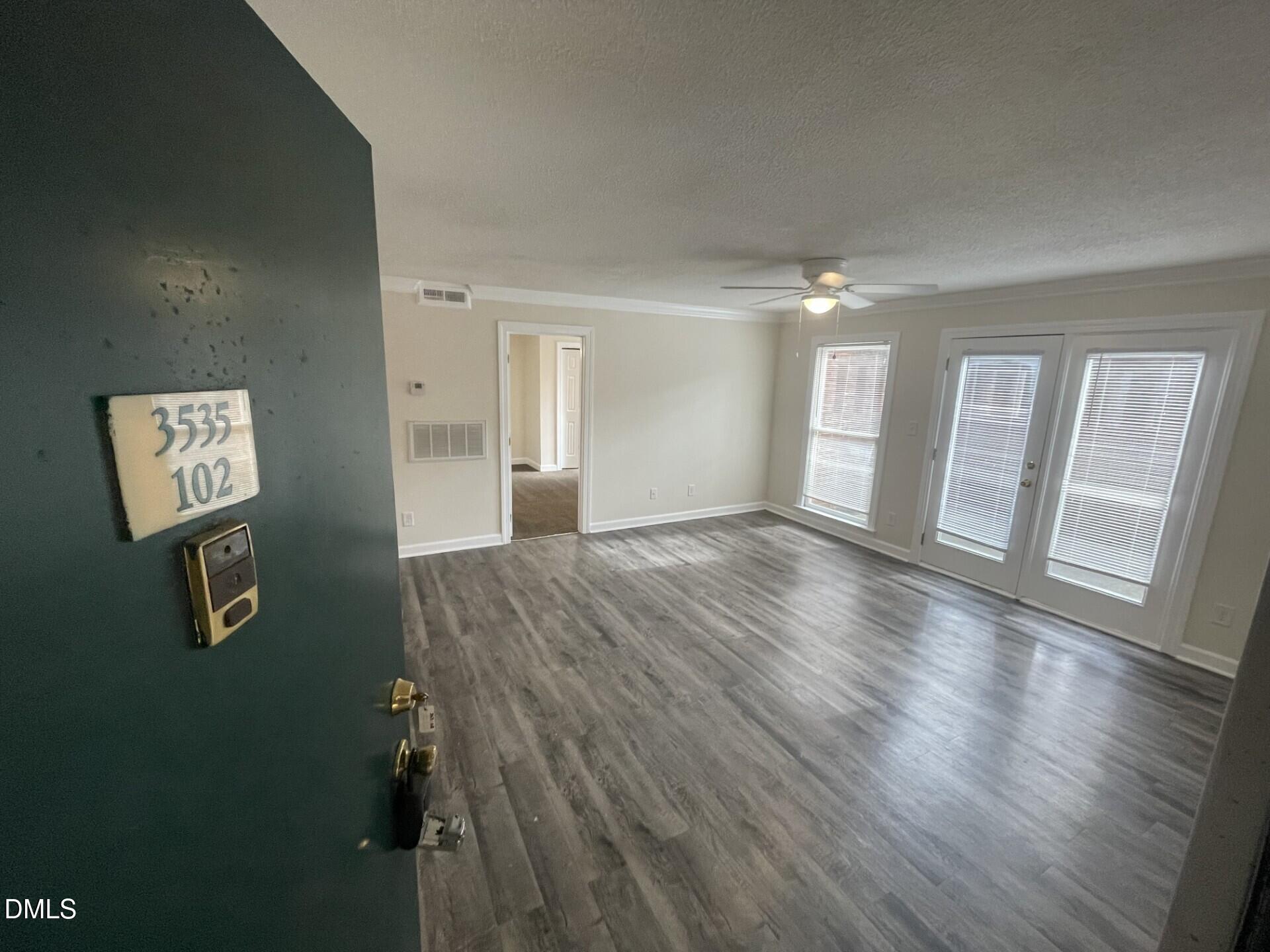 3535 Ivy Commons Drive, Unit 102 Raleigh, NC 27606 - Photo 2 of 9 wooden floor in a hall with an entryway