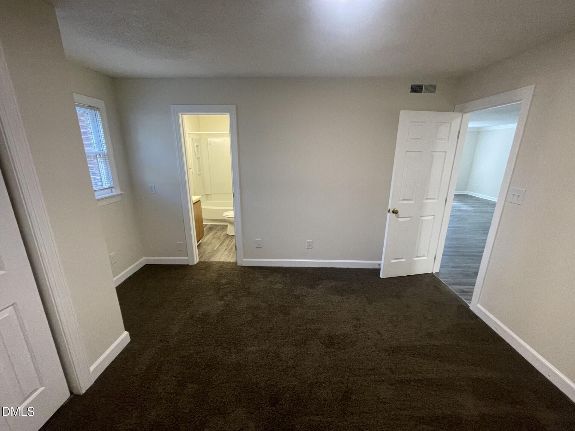 3535 Ivy Commons Drive, Unit 102 Raleigh, NC 27606 - Photo 5 of 9 a view of an empty room with wooden floor and a window