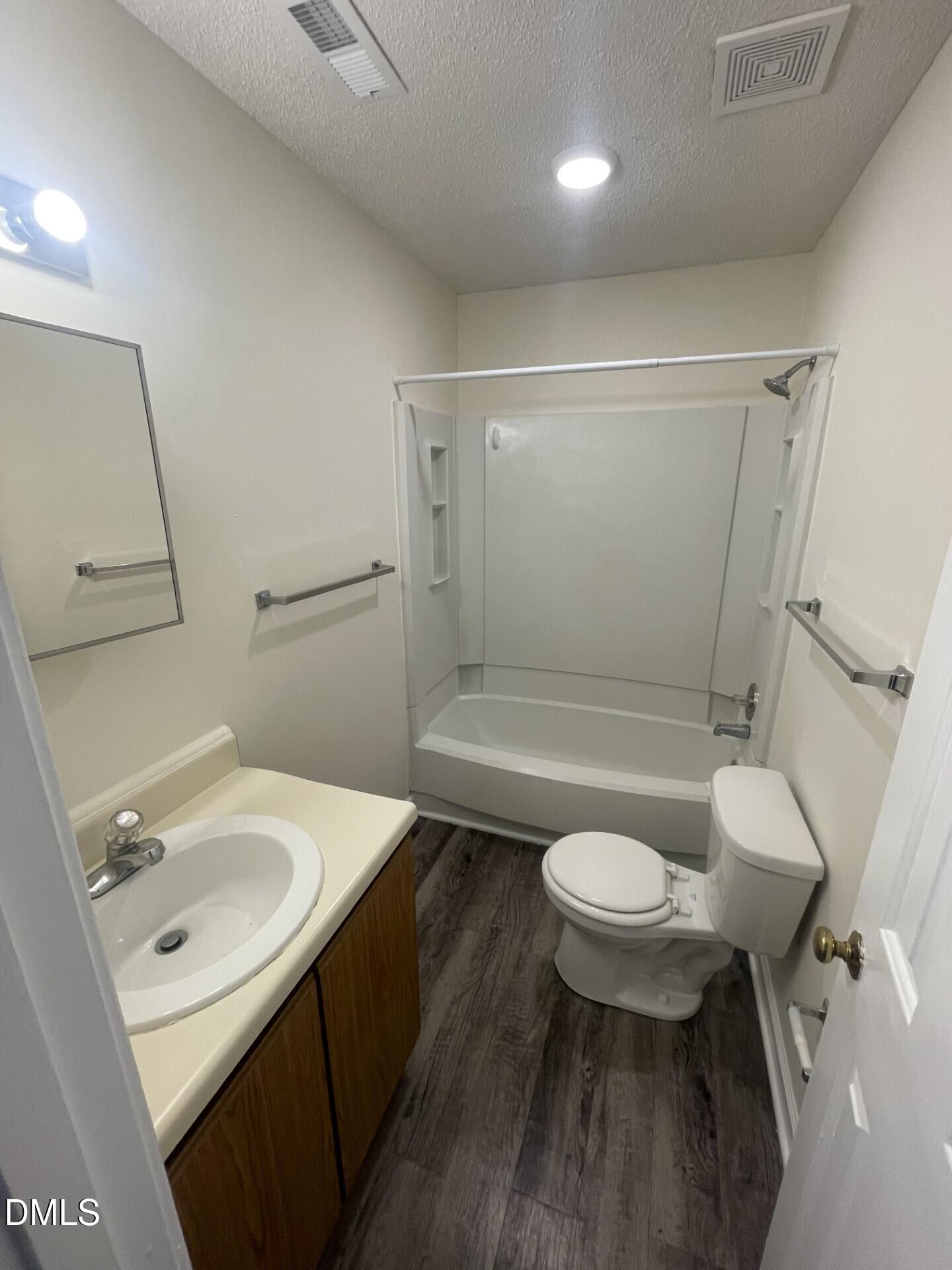 3535 Ivy Commons Drive, Unit 102 Raleigh, NC 27606 - Photo 6 of 9 a bathroom with a sink a toilet a mirror and vanity