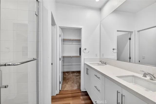 a spacious bathroom with a double vanity sink a mirror and shower