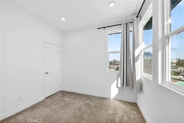 a view of a hallway with wooden floor and a living room